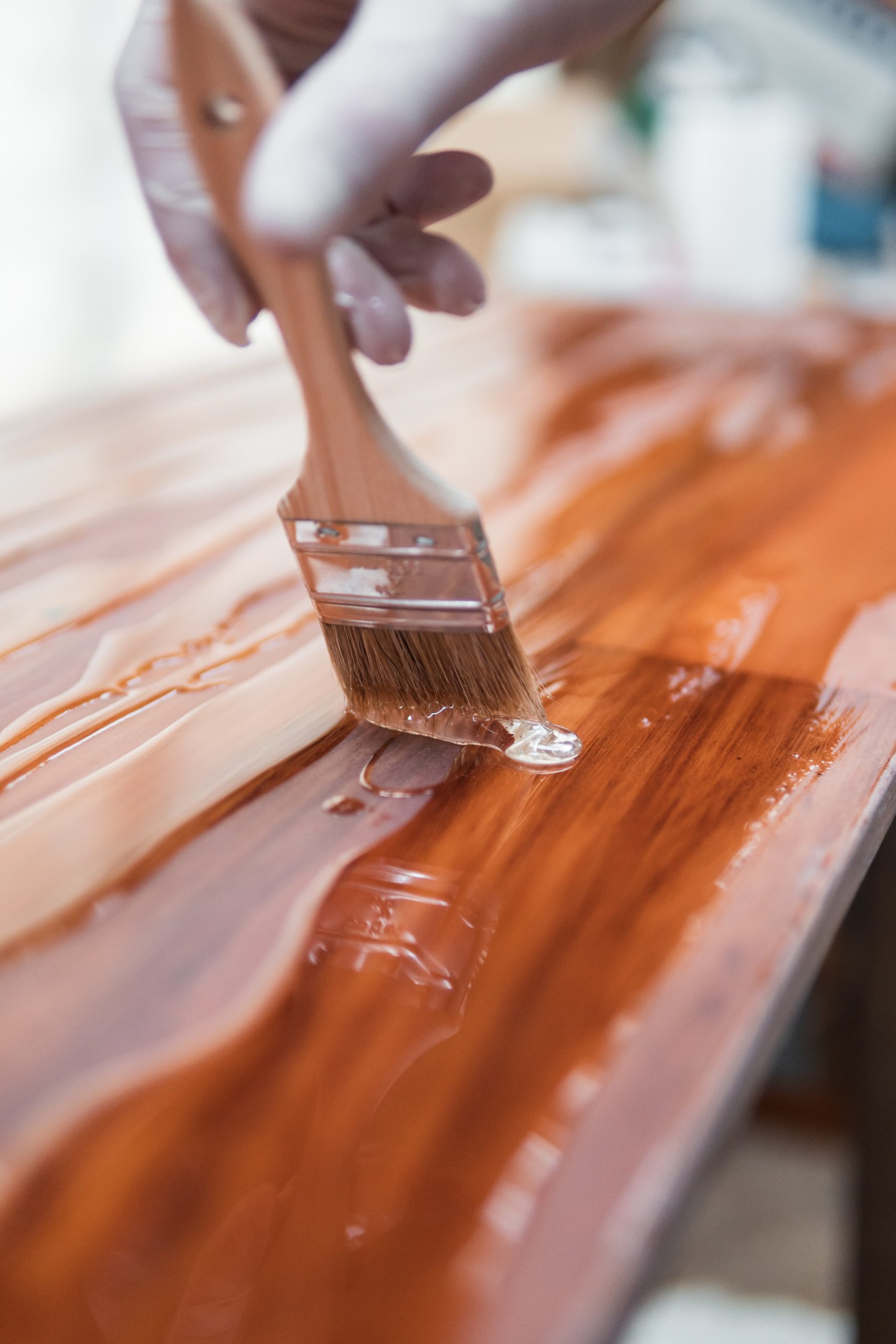 Persona barnizando una mesa de madera